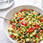 10-Minute Mediterranean Chickpea Salad in a white bowl on a wooden table