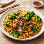 Blackstone Garlic Butter Noodle Stir-Fry sizzling on a griddle