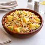 A colorful bowl of fresh Pineapple Slaw with cabbage and carrots.