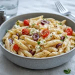 Greek Pasta with Feta and Olives in a white bowl on a wooden table
