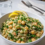 A vibrant bowl of Lemon Herb Quinoa with Chickpeas garnished with lemon slices.