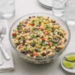 Mexican Macaroni Salad With Corn in a white bowl on a wooden table.
