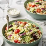 Quick Mediterranean Orzo Pasta Salad in a white bowl on a marble counter