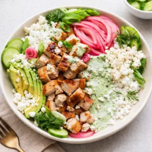 A vibrant Green Goddess Bowl with grilled chicken and avocado.