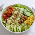 A vibrant Grilled Chicken and Avocado Salad Bowl with creamy dressing.