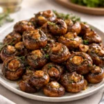 A bowl of glossy Roasted Balsamic Soy Garlic Mushrooms garnished with thyme