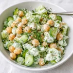 Fresh Tzatziki Chickpea Salad in a bowl with tomatoes and herbs